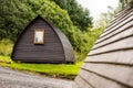 A wooden cottage lodge in a Scottish camp in Highlands with green grass and a blurred house Royalty Free Stock Photo