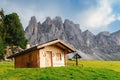 Wooden cottage overlooking the impressive Dolomites rock formation in northern Italy