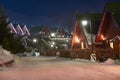 Wooden cottage in the snow and with garlands on a winter evening. A house for holidays and vacations in the forest Royalty Free Stock Photo