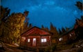 wooden cottage in the woods with starry milky way at night in the sky, night sky with stars Royalty Free Stock Photo