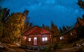 wooden cottage in the woods with starry milky way at night in the sky, night sky with stars Royalty Free Stock Photo