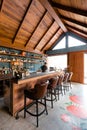 Wooden Counter bar with many brands of liquor on the shelf with moving bartender Mixologist at the hip roof restaurant