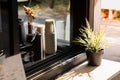 Wooden counter with beautiful flower of the vintage coffee cafe shop on sideroad in urban city shows detail of coffee machine and Royalty Free Stock Photo