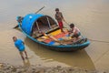 Wooden country boat stuck in mud at low tide on the Ganges river near Outram ghat, Kolkata.