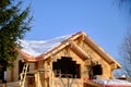 Wooden country house made of timber under construction. Suburban winter landscape