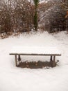 wooden covered public bench snow outside winter grass covered white