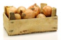 A wooden crate with brown onions