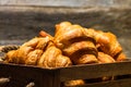 Wooden crate with delicious, fresh croissants isolated. French breakfast concept