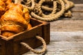 Wooden crate with delicious and fresh croissants on the table - french breakfast Royalty Free Stock Photo