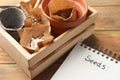 Wooden crate with different vegetable seeds and notebook on table Royalty Free Stock Photo