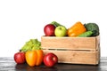 Wooden crate filled with fresh vegetables and apples on table Royalty Free Stock Photo