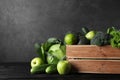 Wooden crate, fresh green fruits and vegetables on dark background. Royalty Free Stock Photo