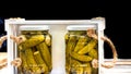 Wooden crate with glass jars with pickles isolated. Preserved food concept, canned vegetables isolated in a rustic composition Royalty Free Stock Photo