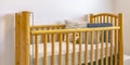 Wooden crib with mattress pillows and stuffed toy