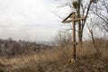 Wooden cross on an abandoned grave with stones located on a hill