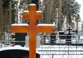 Wooden cross and artificial flowers on the grave of an Orthodox cemetery in the winter. Royalty Free Stock Photo