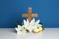 Wooden cross, crown of thorns, Easter eggs and blossom lilies on table Royalty Free Stock Photo
