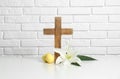 Wooden cross, Easter eggs and blossom lily on table Royalty Free Stock Photo