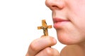 Wooden cross in hand leaning against the female lips Royalty Free Stock Photo