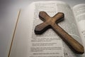 Wooden cross laying over open bible at Matthew 27:35