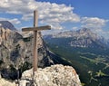 Wooden cross on a mountain peak with mountains, valley with forest and blue sky with white clouds in the background Royalty Free Stock Photo