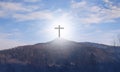 Wooden cross on the mountain. The symbol of death. Atonement for Sins. Against the sky