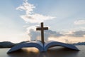 The wooden cross over opened bible on wooden table, Beautiful sky background Royalty Free Stock Photo