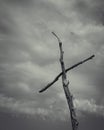 a wooden cross is standing against a dark cloudy sky background Royalty Free Stock Photo