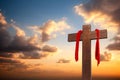 Wooden cross with red cloth wrapped around on sunset sky background Royalty Free Stock Photo