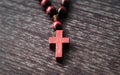 Wooden cross, rosary on wooden background. Symbol of Christianity and faith. Prayer. Concept Palm Sunday, Good Friday, Easter. Royalty Free Stock Photo