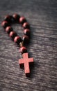 Wooden cross, rosary on wooden background. Symbol of Christianity and faith. Prayer. Concept Palm Sunday, Good Friday, Easter. Royalty Free Stock Photo