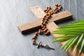 Wooden cross, rosary and palm on black marble background, palm sunday concept Royalty Free Stock Photo