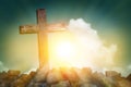 Wooden cross shape on rocky hill at sunset with blue sky