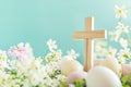 Wooden cross with spring flowers and easter eggs against tender blue background