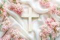 Wooden cross with tender pink spring flowers on white silk background Royalty Free Stock Photo