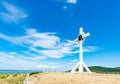 A wooden cross on top of a hill. Orthodox white cross glows on the top of the hill on the background of blue sky and of green gras Royalty Free Stock Photo