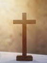 Wooden cross on white altar cloth, rays of light in background. Christian faith.