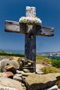 Wooden cross with wreath in background of landscape