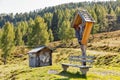 Wooden crucifix with Alpine mountain landscape in Austria.