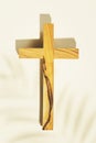 Wooden crucifixion with palm leaf shadow n a light background