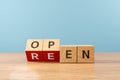 Wooden cube block flip over word REEN to OPEN on wood table, 3D render