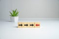 Wooden cube block with red arrow facing the opposite direction black arrows, Unique, think different, individual and Royalty Free Stock Photo