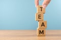 Wooden cube block word TEAM on wood table, 3D render