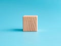 Wooden cube on blue background with space for text Royalty Free Stock Photo