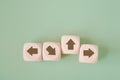 Wooden cube with brown arrow pointing up, difference direction from the others for think different, individual unique