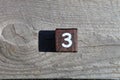 Wooden cube with the number three