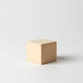 Wooden cube placed on a neutral white surface. The cube displays visible grain Royalty Free Stock Photo