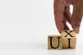 A wooden cube on a white table with text UI, UX. Concept of development and design and development, user interface, user Royalty Free Stock Photo