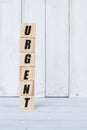 wooden cube, with the word urgent, with white wooden background