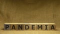 Wooden cubes with black word PANDEMIA on sackloth background. Pandemia and Covid-19 concept